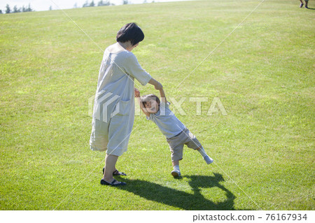 Parents and children playing on the grass in summer Parents and children playing on the grass in summer 76167934