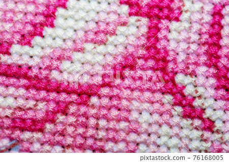 Close-up of a cross-stitched section of a canvas with a pattern Close-up of a cross-stitched section of a canvas with a pattern 76168005