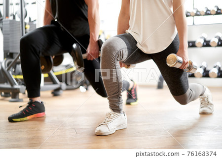 Asian couple doing dumbbell front lunge 76168374