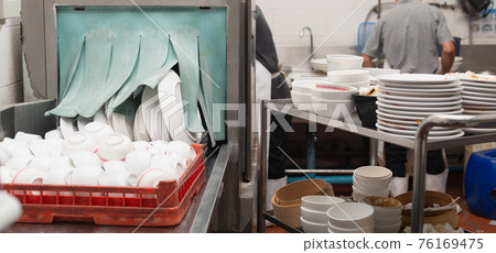 Man washing dish in sink 76169475