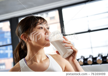 Asian women drinking protein after training 76169499