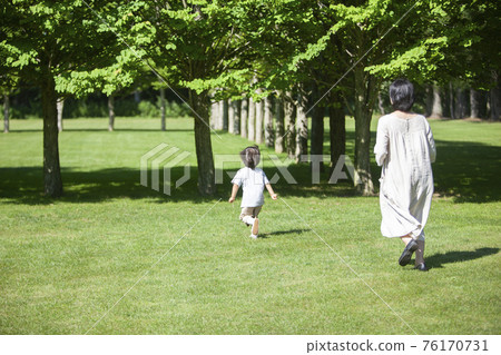 Parents and children playing tag in a summer park 76170731