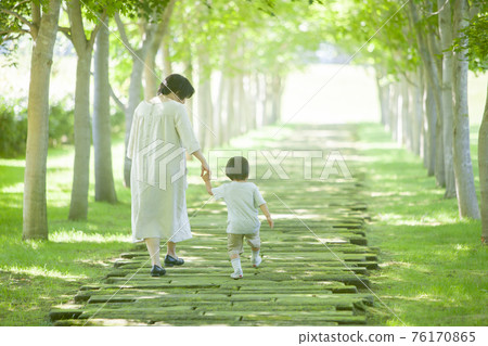 Parents and children walking in a green tunnel 76170865