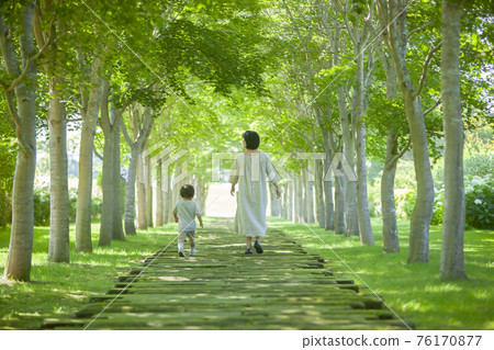 Parents and children walking in a green tunnel 76170877