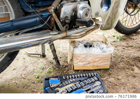 A motorcycle that is changing oil, a turnip under maintenance A motorcycle that is changing oil, a turnip under maintenance 76171986