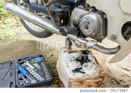 A motorcycle that is changing oil, a turnip under maintenance A motorcycle that is changing oil, a turnip under maintenance 76171987