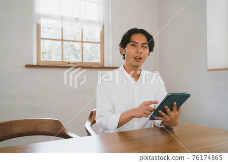 在家裡經營平板電腦的男士 76174865