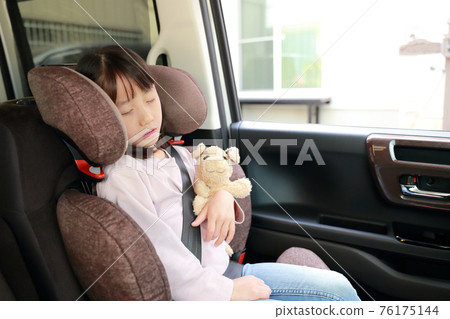 A girl who sleeps while sitting in a junior seat attached to the passenger seat A girl who sleeps while sitting in a junior seat attached to the passenger seat 76175144