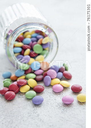 Jar with multicolored dragee candies Jar with multicolored dragee candies 76175301