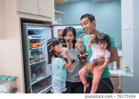 happy asian family enjoy having some meal in the kitchen 76175804