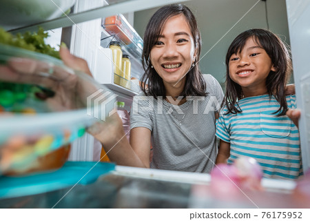 asian mother and her daughter having snack time together 76175952