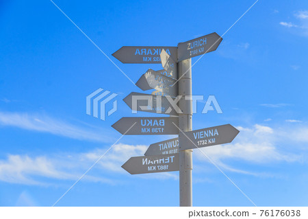Sign indicating the directions and distances to major cities in the world on observation deck on a top of Tahtali mountain near Kemer, Antalya Province in Turkey 76176038