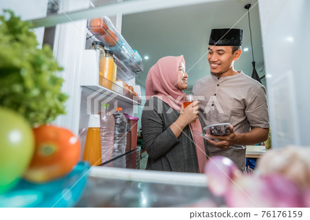 beautiful couple muslim breaking the fast iftar in front of the open fridge beautiful couple muslim breaking the fast iftar in front of the open fridge 76176159