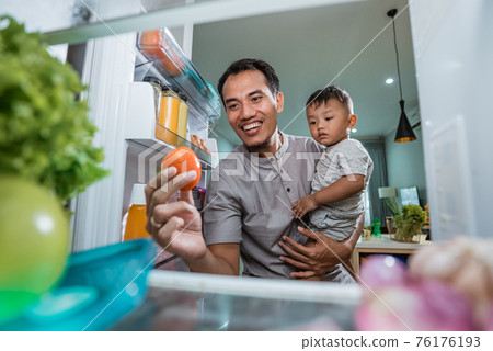 father and son open refrigerator at home looking for some food father and son open refrigerator at home looking for some food 76176193