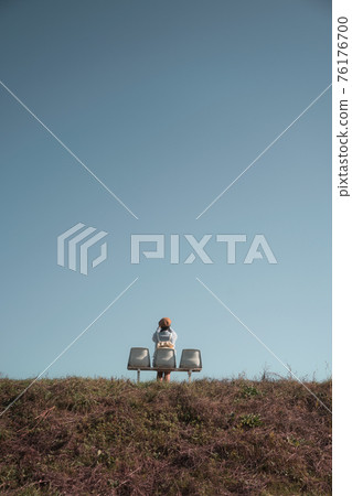 Pretty woman sitting on chair and taking a picture on hill Pretty woman sitting on chair and taking a picture on hill 76176700