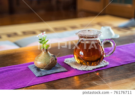 Hot tea and flower in vase on wooden table Hot tea and flower in vase on wooden table 76176711