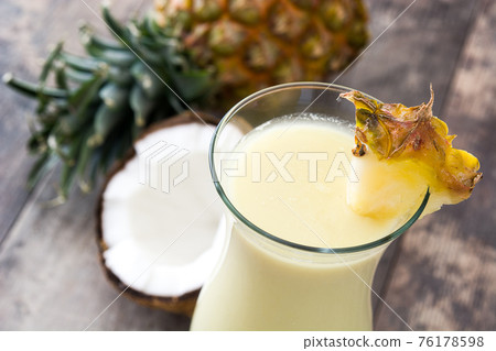 Pina colada cocktail in glass on wood 76178598