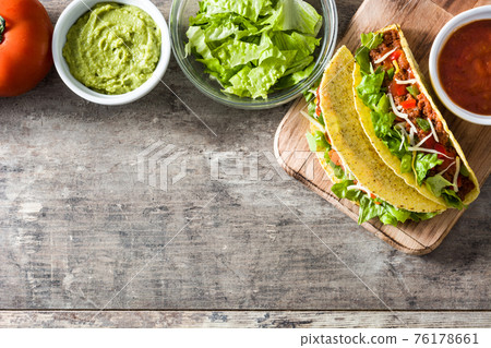 Traditional Mexican tacos with meat and vegetables on wood Traditional Mexican tacos with meat and vegetables on wood 76178661