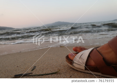 日落時分，穿著人字拖在沙灘上小憩 76179355