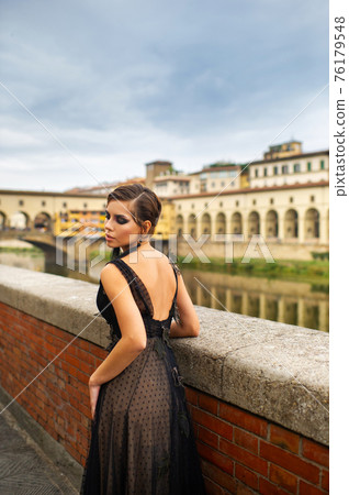 Beautiful stylish bride in a black dress stands on the embankment in Florence, Italy Beautiful stylish bride in a black dress stands on the embankment in Florence, Italy 76179548