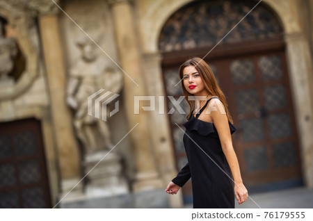 Stylish young girl in a black dress on the street of the city of BRNO in the morning.Czech 76179555