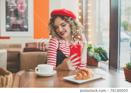 Cute happy young woman with smartphone in cafe Cute happy young woman with smartphone in cafe 76180093