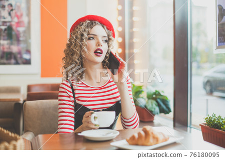 Pretty happy young woman with smartphone in cafe Pretty happy young woman with smartphone in cafe 76180095