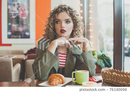 Lovely woman sitting in city street cafe Lovely woman sitting in city street cafe 76180098