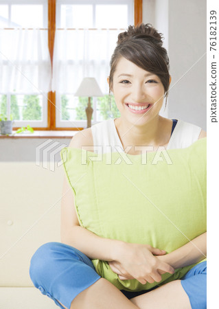 Woman sitting on the couch Woman sitting on the couch 76182139