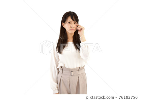 A casual woman who puts her finger on her eyes and feels sad White background A casual woman who puts her finger on her eyes and feels sad White background 76182756