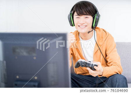 一個男人在房間裡玩網絡遊戲 一個男人在房間裡玩網絡遊戲 76184690