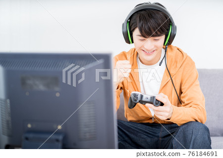 一個男人在房間裡玩網絡遊戲 一個男人在房間裡玩網絡遊戲 76184691