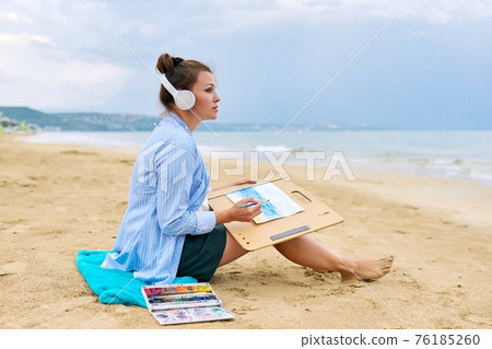 Relaxation on sea, mature woman in headphones with watercolors painting Relaxation on sea, mature woman in headphones with watercolors painting 76185260