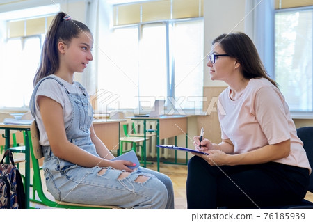 Woman school psychologist talking and helping student, teenage girl 76185939