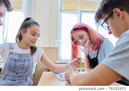 Group of teenage students in the classroom sitting at their desks Group of teenage students in the classroom sitting at their desks 76185955