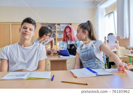 Group of teenage students in the classroom sitting at their desks Group of teenage students in the classroom sitting at their desks 76185962