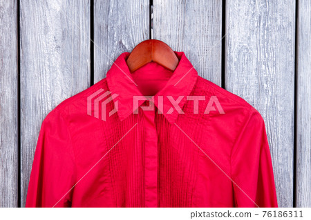 Close up top of red shirt on hanger. 76186311