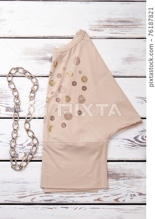 Folded beige blouse and chain necklace. Folded beige blouse and chain necklace. 76187821