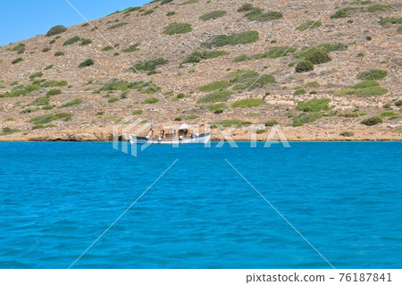Small tourist motor boat in the Aegean Sea, near the Greek island of Spinalonga Small tourist motor boat in the Aegean Sea, near the Greek island of Spinalonga 76187841
