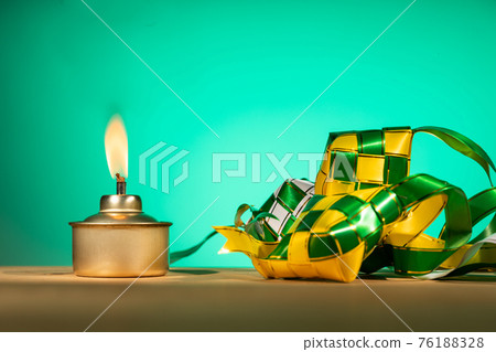 Conceptual traditional Malay oil lamp named pelita with decorative ketupat for Hari Raya Aidilfitri celebration Conceptual traditional Malay oil lamp named pelita with decorative ketupat for Hari Raya Aidilfitri celebration 76188328
