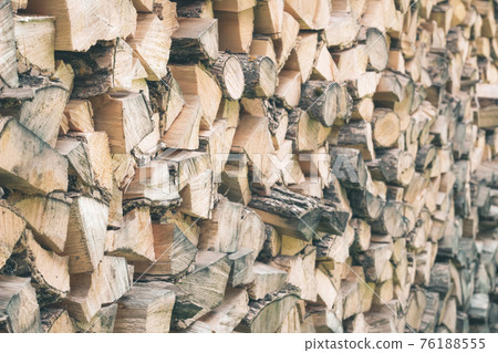 Environmentally friendly fuel. Firewood for a rustic stove. Wood texture. Rustic background Ecologicaly clean fuel. Firewood is laid wall 76188555