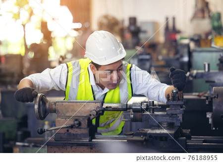 A worker in glasses standing near industrial equipment and verifies production. man operating machine in the factory 76188955