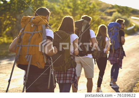 Group of young tourists hikers hiking in natural rocks with backpacks Group of young tourists hikers hiking in natural rocks with backpacks 76189622