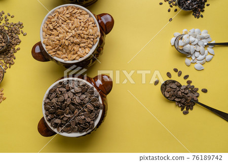 Watermelon, pumpkin and melon seeds on a yellow background Watermelon, pumpkin and melon seeds on a yellow background 76189742