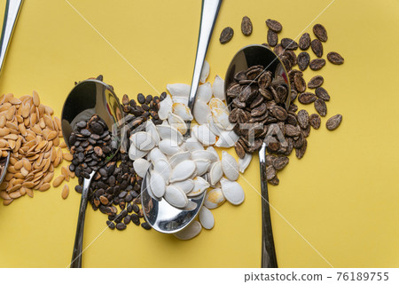 Watermelon, pumpkin and melon seeds on a yellow background Watermelon, pumpkin and melon seeds on a yellow background 76189755