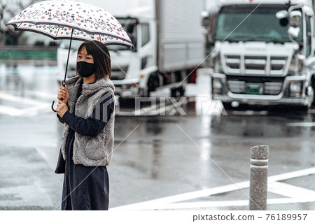 Woman with an umbrella rain 76189957