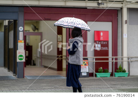 Woman with an umbrella rain 76190014