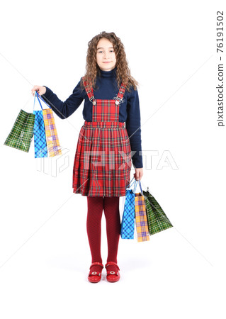 Child with a packaging checkered texture isolated on white background. Girl likes shopping on sale season. Holiday present, shopping. Child with a packaging checkered texture isolated on white background. Girl likes shopping on sale season. Holiday present, shopping. 76191502