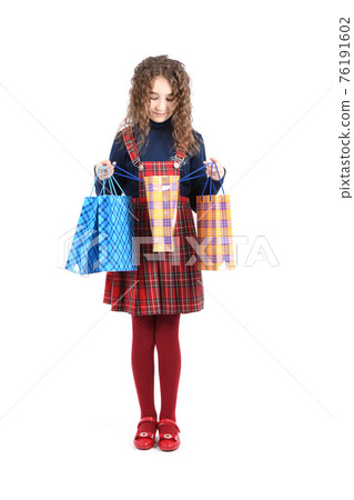 Child with a packaging checkered texture isolated on white background. Girl likes shopping on sale season. Holiday present, shopping. Child with a packaging checkered texture isolated on white background. Girl likes shopping on sale season. Holiday present, shopping. 76191602