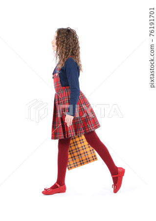 Child with a yellow packaging checkered texture  isolated on white background. Holiday present, shopping. 76191701